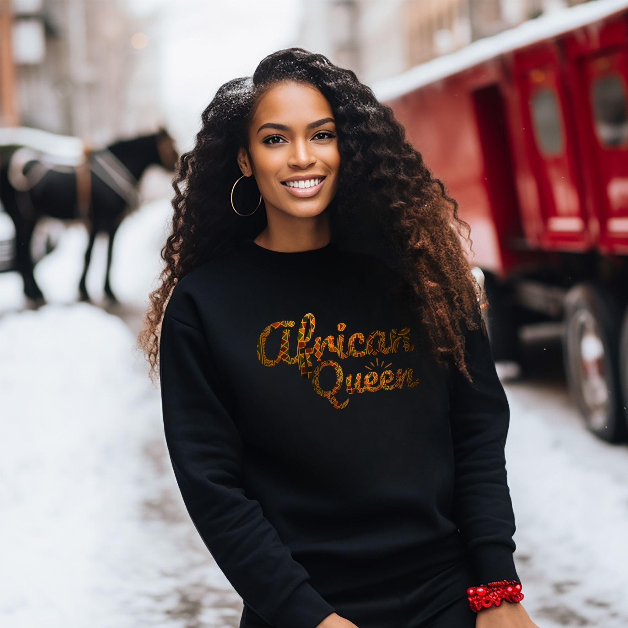 Woman wearing a black sweatshirt with 'African Queen' text, standing in an urban setting.